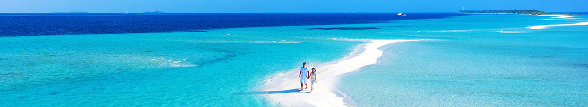 Couple walking on a beach in the Maldives